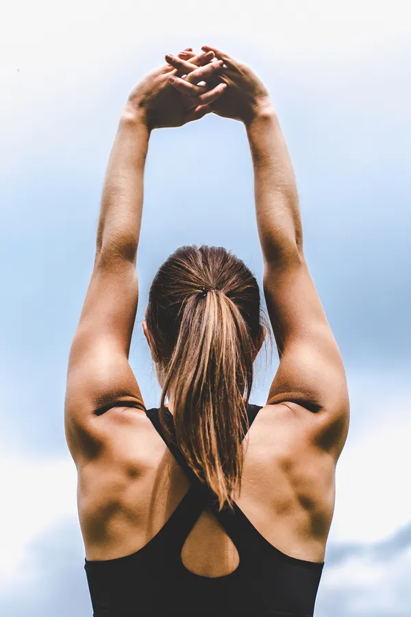 GLP-1-Weight-Loss-Injections-Treatment A toned woman seen from behind stretching her arms into the air. Get GLP-1 Weight Loss Injections from Fonthealth in Niagara.